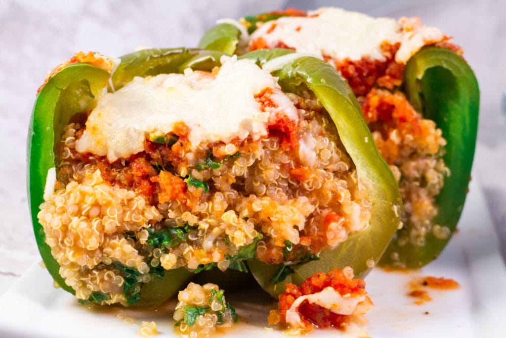 Vegetarian Stuffed Peppers recipe recipe made with quinoa, kale and covered in cheese!  This easy healthy recipe is perfect to add to your meatless dinner menu! Vegan option offered. 