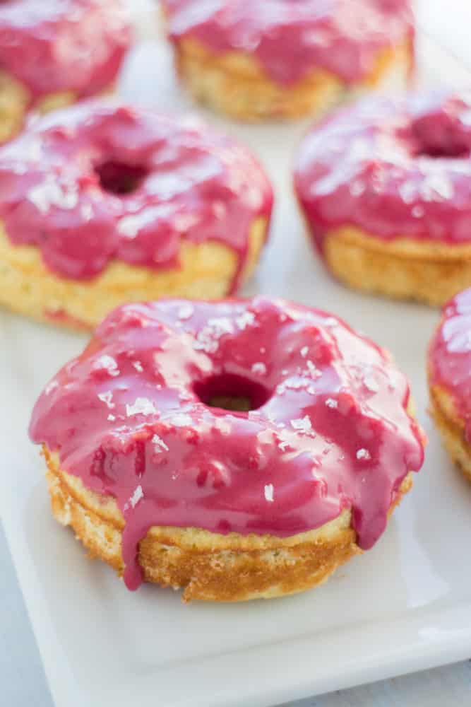 GLUTEN FREE Baked Vanilla Donuts recipe with a bright pink frosting on top!  The icing glaze is completely all natural!   These cute donuts are great for birthday party, bridal party and wedding desserts!  They're always a favorite at PTA meetings too! 