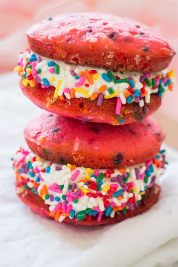 It's time to celebrate with these classic Vanilla Whoopie Pies! This easy recipe makes delicious vanilla whoopie cake pies with marshmallow creme filling (just like homemade Amish Whoopie Pies!). These pretty treats are perfect for a birthday party or baby shower celebration (Its a girl!) with the help of pink food coloring and rainbow sprinkles. 