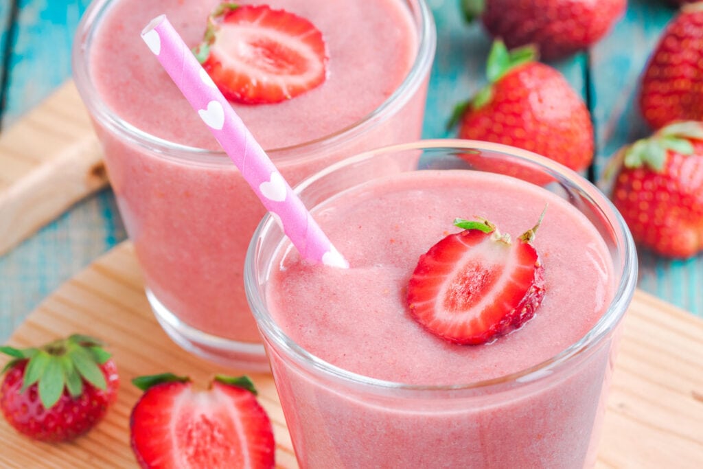 pink smoothies in glass on table.