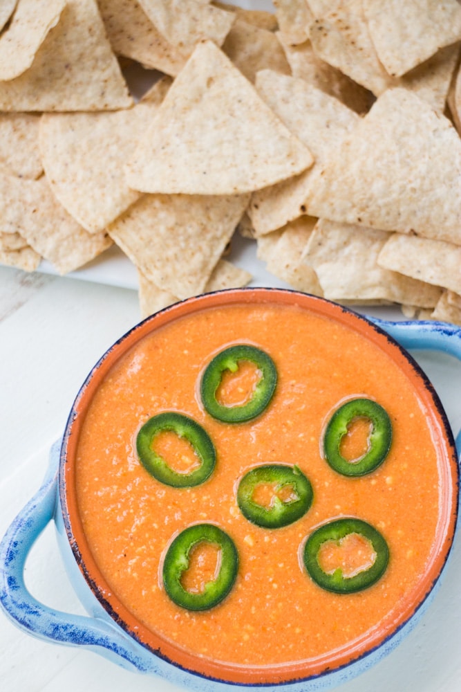 Slow Cooker Tomato Cheese Dip is a creamy easy to make dip that uses fresh tomatoes, peppers and Velveeta cheese! This simple homemade recipe is ready in 2 hours in the slow cooker and perfect to serve with tortilla chips for your next party! We especially love this dip for Mexican meals! 