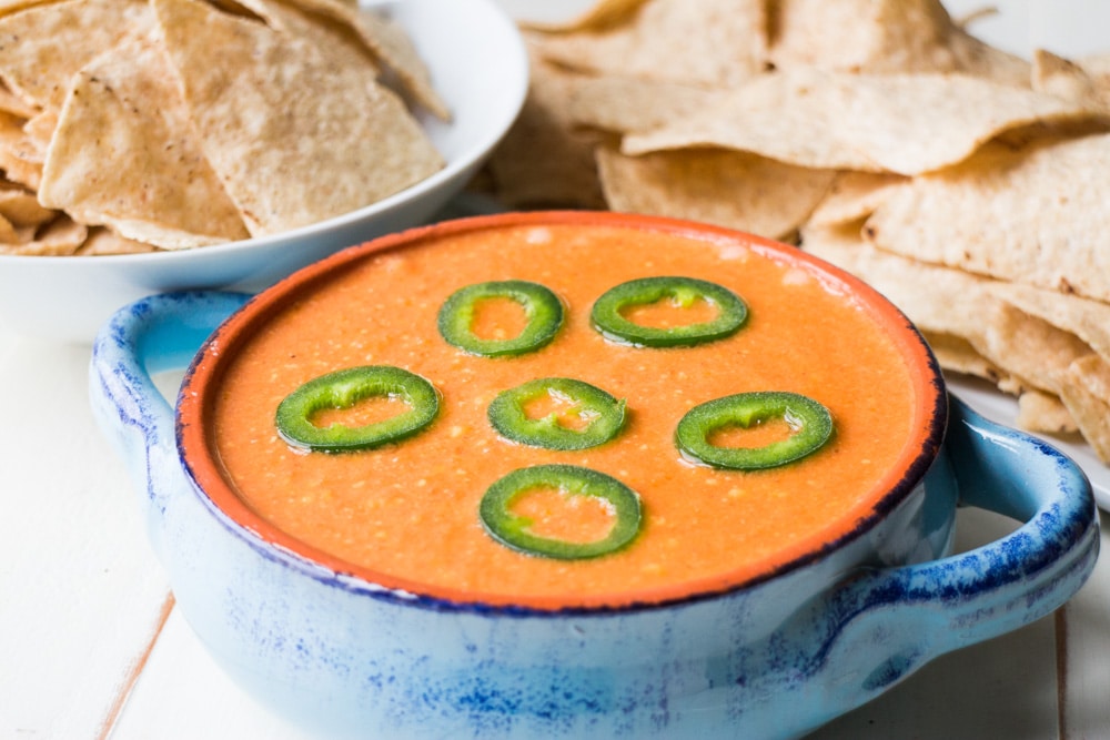 Slow Cooker Tomato Cheese Dip is a creamy easy to make dip that uses fresh tomatoes, peppers and Velveeta cheese! This simple homemade recipe is ready in 2 hours in the slow cooker and perfect to serve with tortilla chips for your next party! We especially love this dip for Mexican meals! 