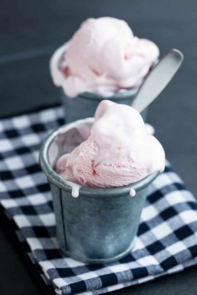 HOMEMADE STRAWBERRY ICE CREAM made with no eggs! This homemade recipe is easy to make in your ice cream maker and is filled with fresh strawberries! It's made with heavy cream, half and half and is eggless! This is one of the best Summer dessert recipes to eat!
