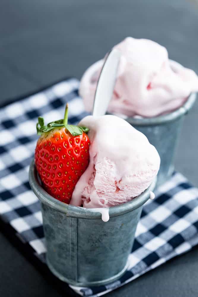 HOMEMADE STRAWBERRY ICE CREAM made with no eggs! This homemade recipe is easy to make in your ice cream maker and is filled with fresh strawberries! It's made with heavy cream, half and half and is eggless! This is one of the best Summer dessert recipes to eat!