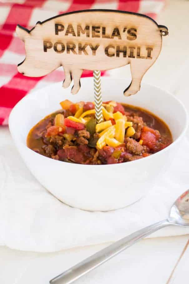 PAMELA'S PORKY Slow Cooker CHILI is made with BACON and SAUSAGE! This pork chili is easy to make in the crockpot with diced tomatoes and beans! It's one of my families favorite comfort food dinners!   Ready in 6 hours on LOW. Serve with shredded cheese and a big piece of crusty bread!