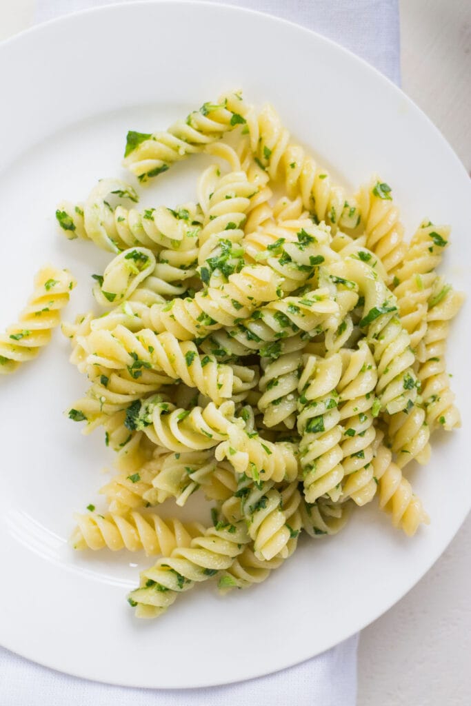 fresh parsley pasta on white plate.