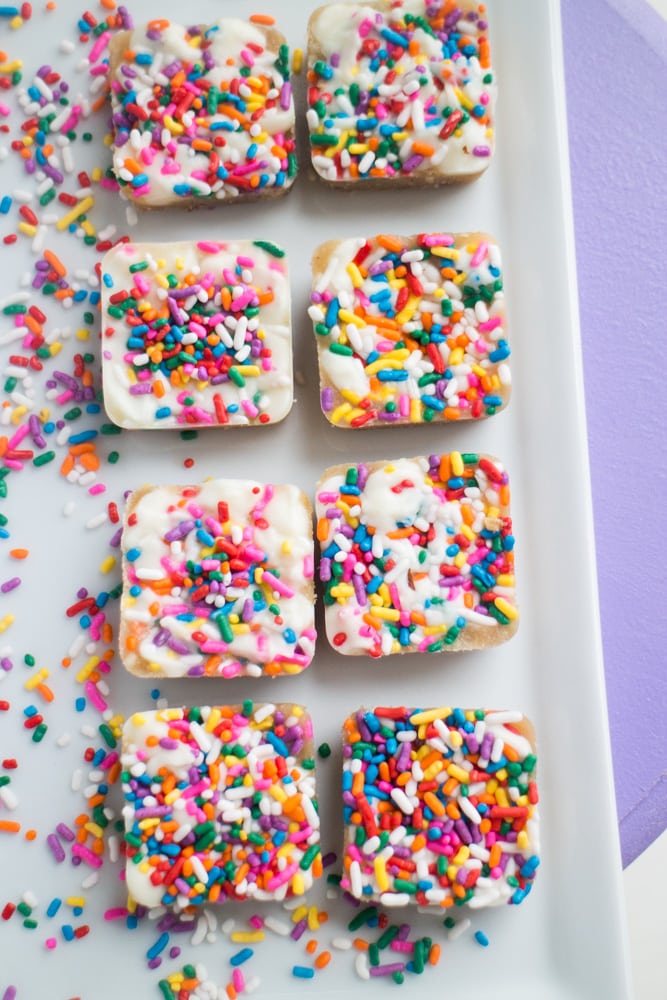 EASY White Chocolate Toffee Recipe with rainbow sprinkles! You're going to love this sticky homemade candy that has a base of crushed up pecans. Cut into squares or break up into bark! 