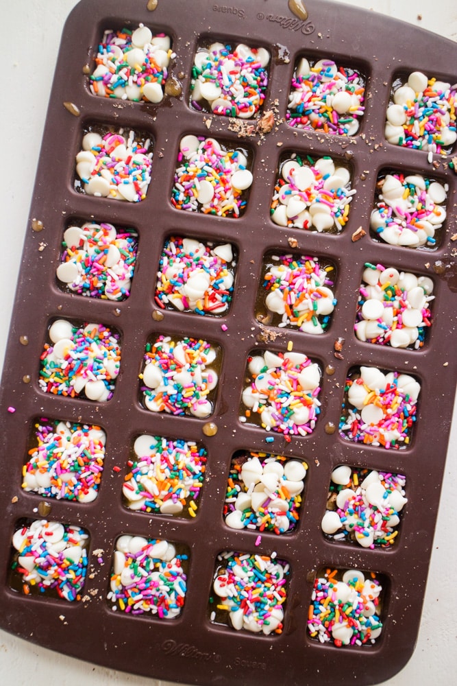 EASY White Chocolate Toffee Recipe with rainbow sprinkles! You're going to love this sticky homemade candy that has a base of crushed up pecans. Cut into squares or break up into bark! 