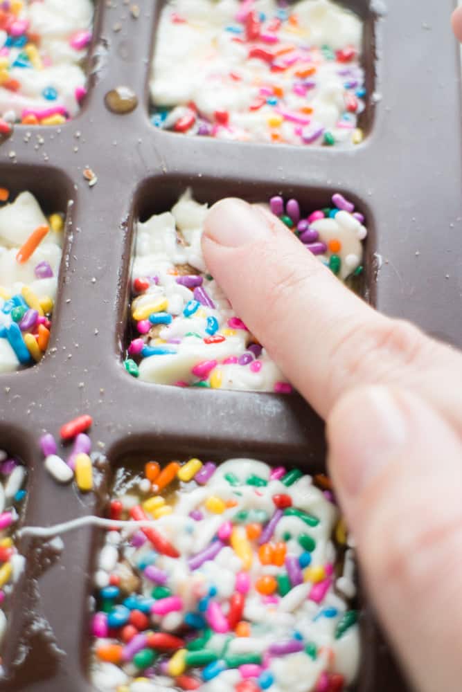 EASY White Chocolate Toffee Recipe with rainbow sprinkles! You're going to love this sticky homemade candy that has a base of crushed up pecans. Cut into squares or break up into bark! 