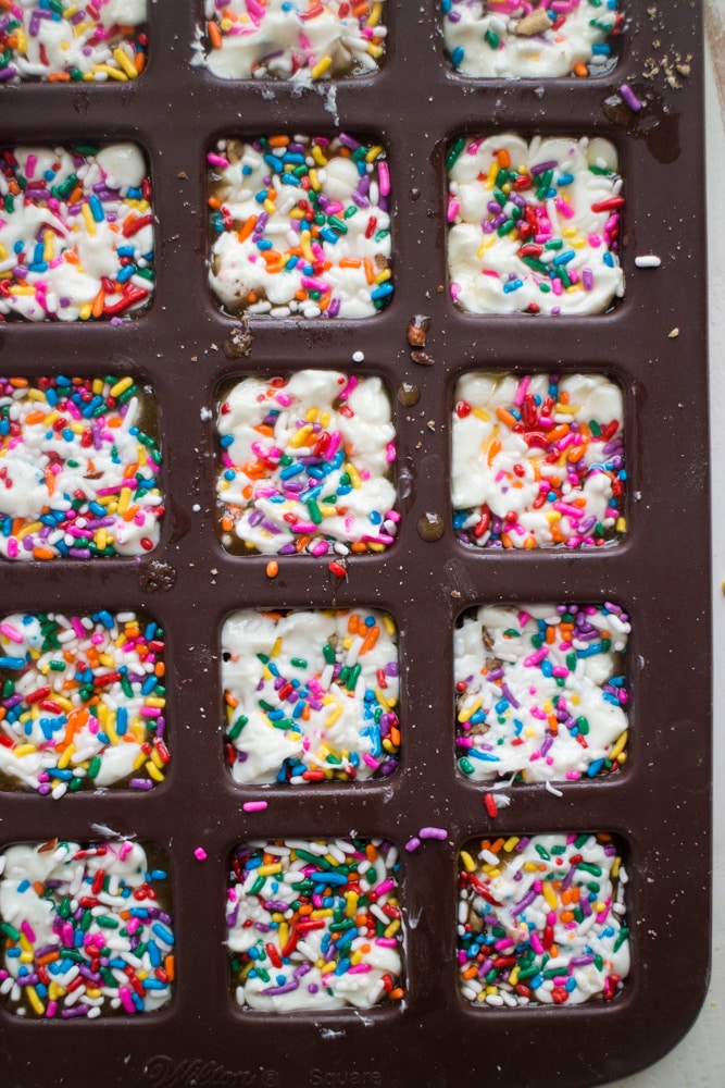 EASY White Chocolate Toffee Recipe with rainbow sprinkles! You're going to love this sticky homemade candy that has a base of crushed up pecans. Cut into squares or break up into bark! 