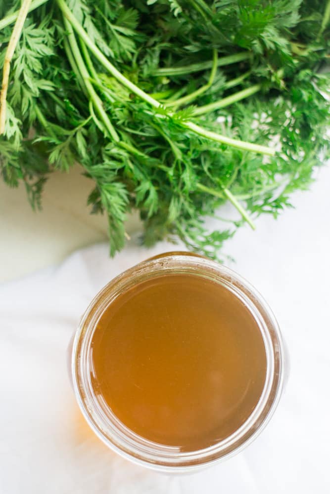 VEGETABLE BROTH made with Carrot Tops!  This easy homemade recipe uses carrot greens to make a healthy vegetarian broth! Carrot greens provide amazing health benefits so they're great to cook with! 