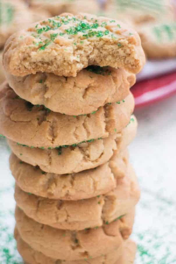 stack of peanut butter cookies with christmas sprinkles on top of them