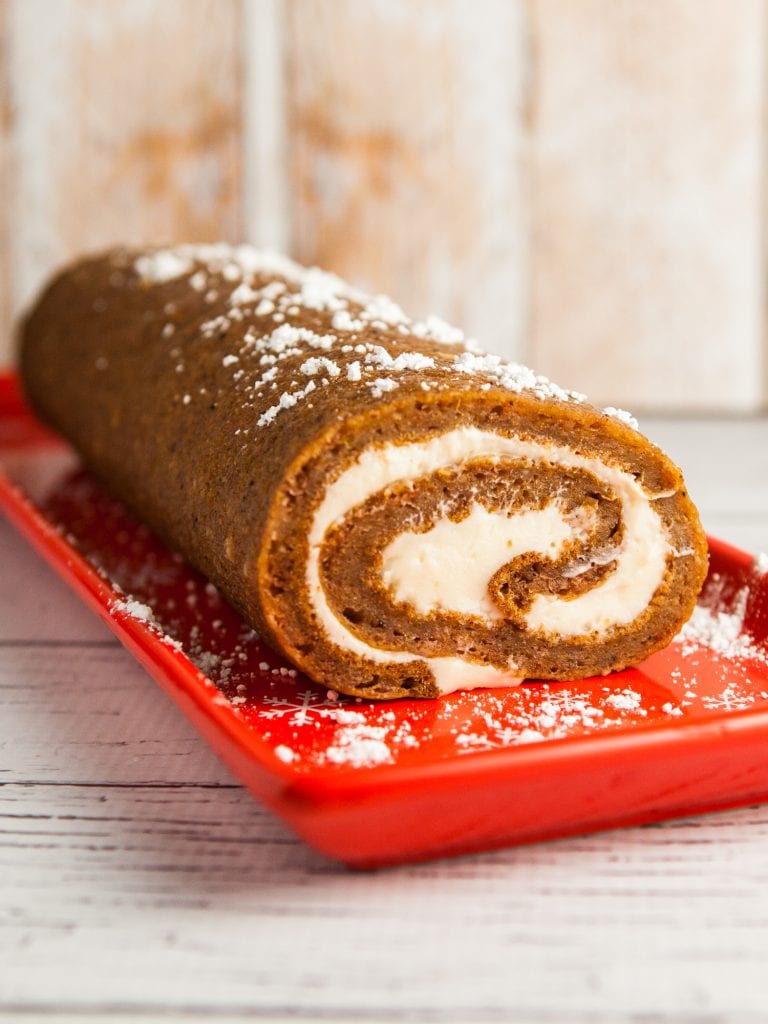 pumpkin roll on red plate on white background.