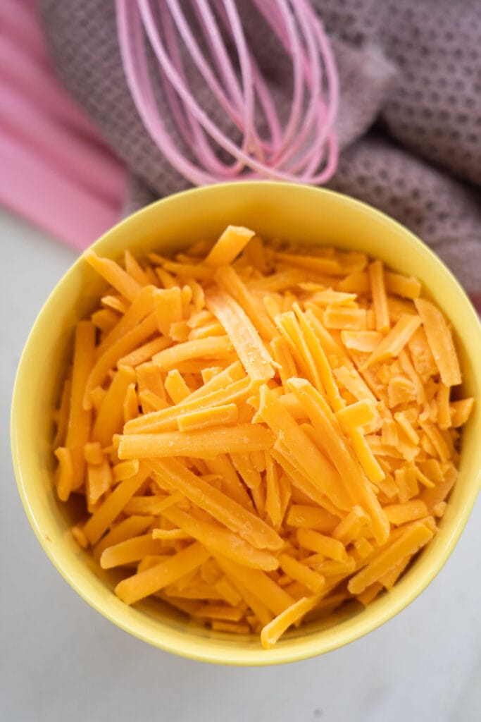 shredded cheese in yellow bowl.