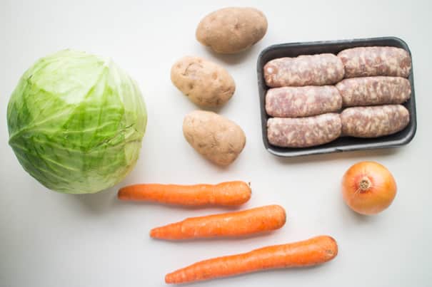 vegetables and sausage on white table. 