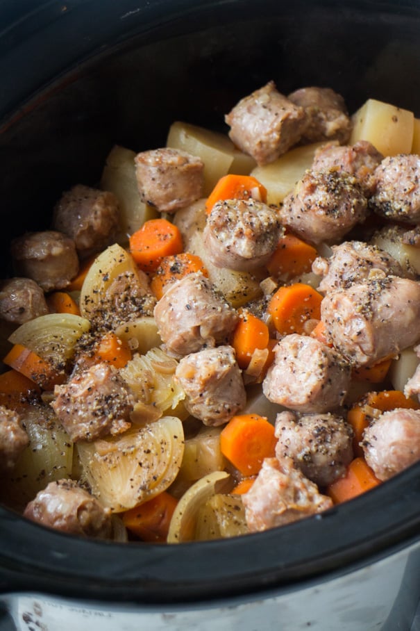 cooked sausage and vegetables in crockpot.