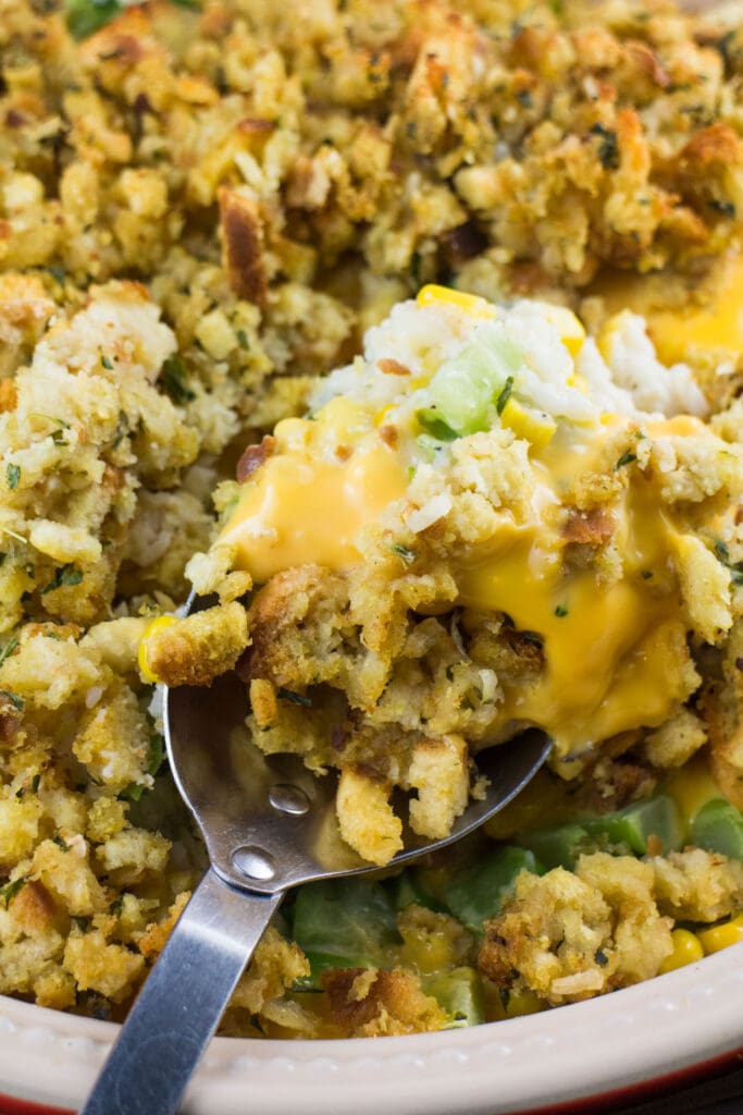 cheesy stuffing on spoon in baking dish.