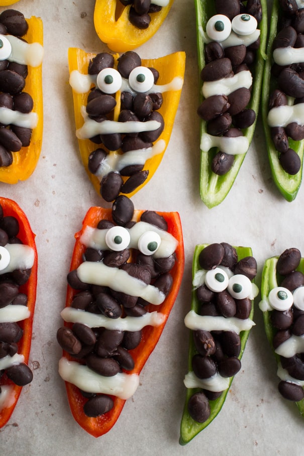 EASY Halloween Stuffed Mummy Peppers recipe for parties and kids!  These mummies only require 3 ingredients and make the cutest appetizer for a party!  This is one of my favorite Halloween food ideas! 
