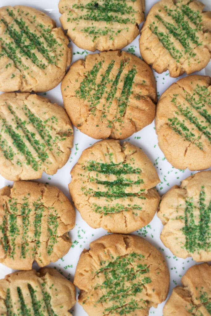 peanut butter sugar cookies, baked, with green festive sprinkle sugar on top.