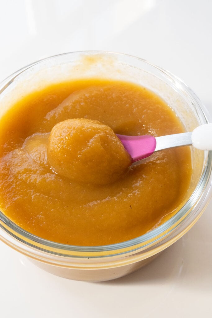 butternut squash apple baby food in bowl with baby spoon in it.