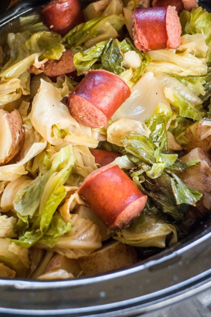 closeup of kielbasa pieces with cabbage, potatoes and onions cooked.