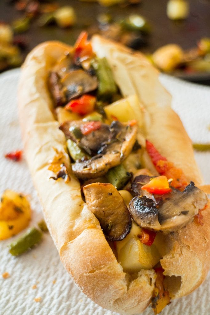 closeup of roasted veggies with cheese on sandwich roll.