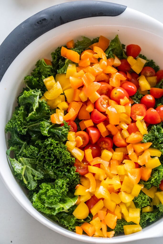 kale with chopped peppers and tomatoes in bowl.