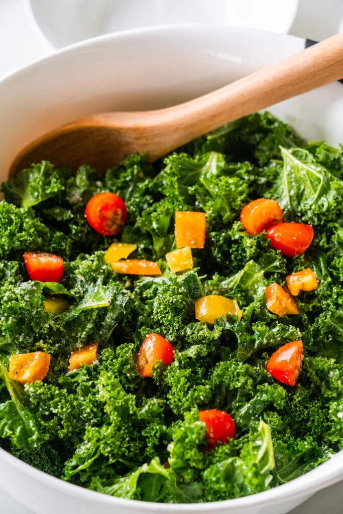 kale salad with tomatoes and peppers in bowl.