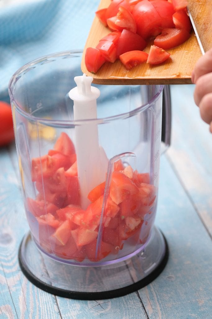 roma tomatoes being poured into food processor