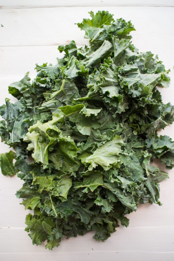chopped up kale on white table.
