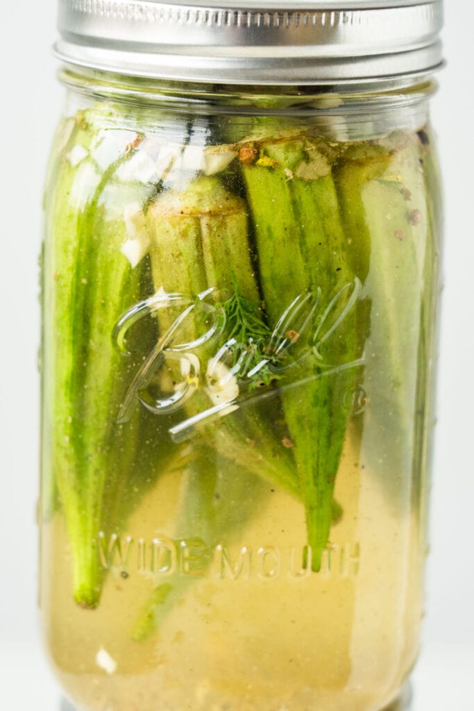 closeup of pickled okra in jar.