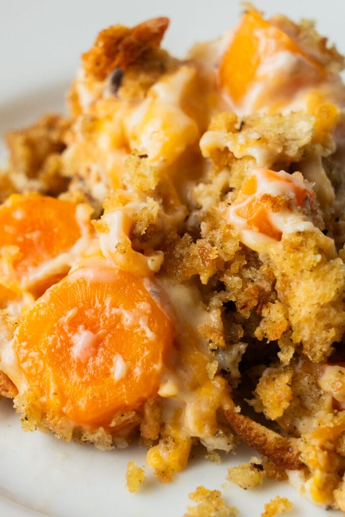 closeup of cheesy carrot casserole with stuffing baked in.