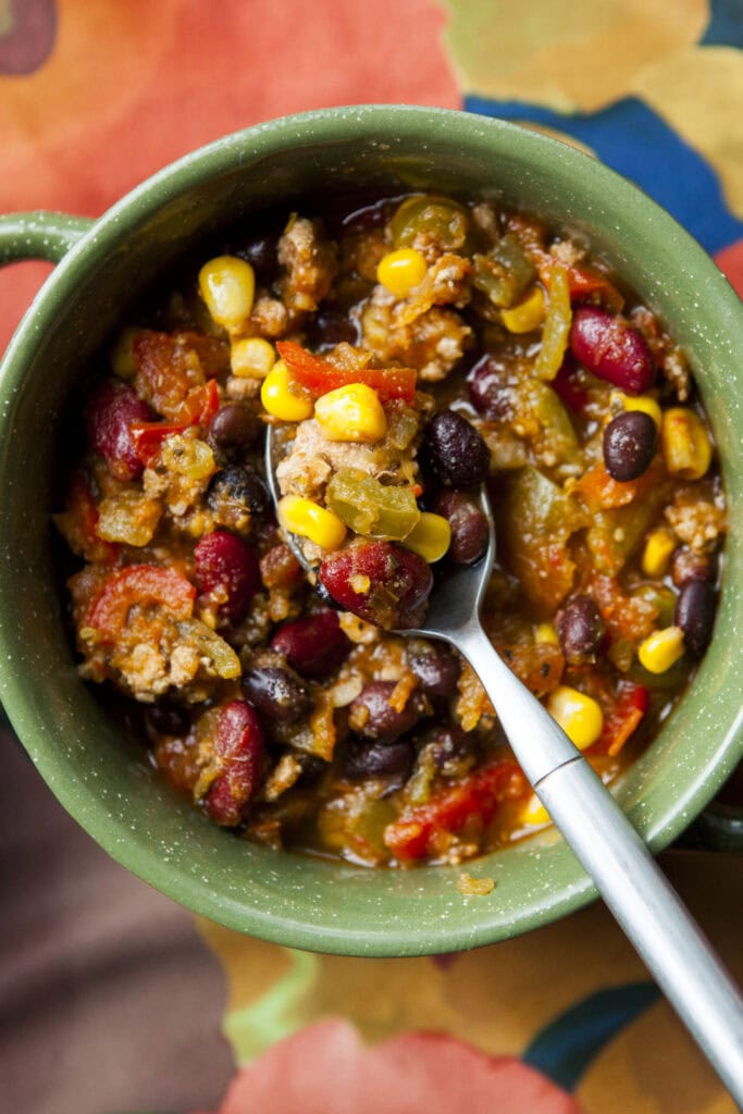 closeup of pumpkin chili in bowl with spoon.