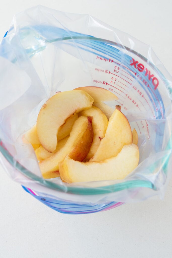 peaches placed in freezer bag in measuring cup.