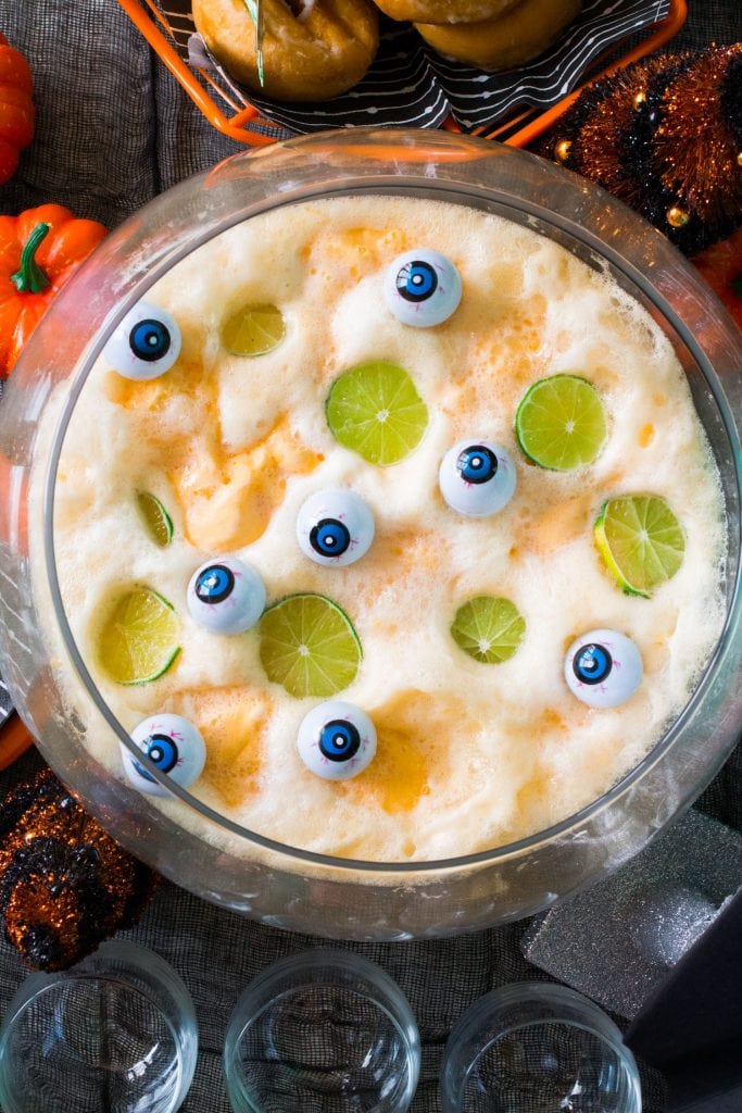 halloween punch in glass bowl on top of halloween decorated table