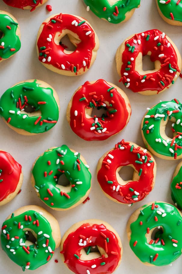 Easy to make Christmas Donut Cookies recipe.   Each sugar cookie is decorated with icing and sprinkles to look like a donut.  If you're looking for the cutest homemade Christmas co