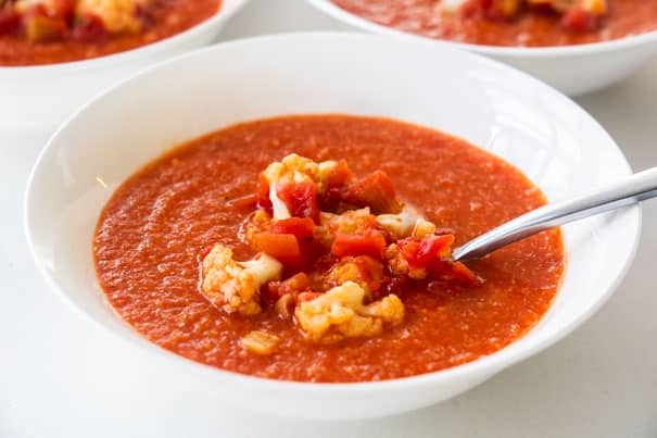 Easy to make creamy tomato soup with cauliflower recipe, ready in 35 minutes.  This homemade soup uses cans of crushed tomatoes and a whole head of cauliflower to make it a healthy dinner the entire family will love.  No milk needed.