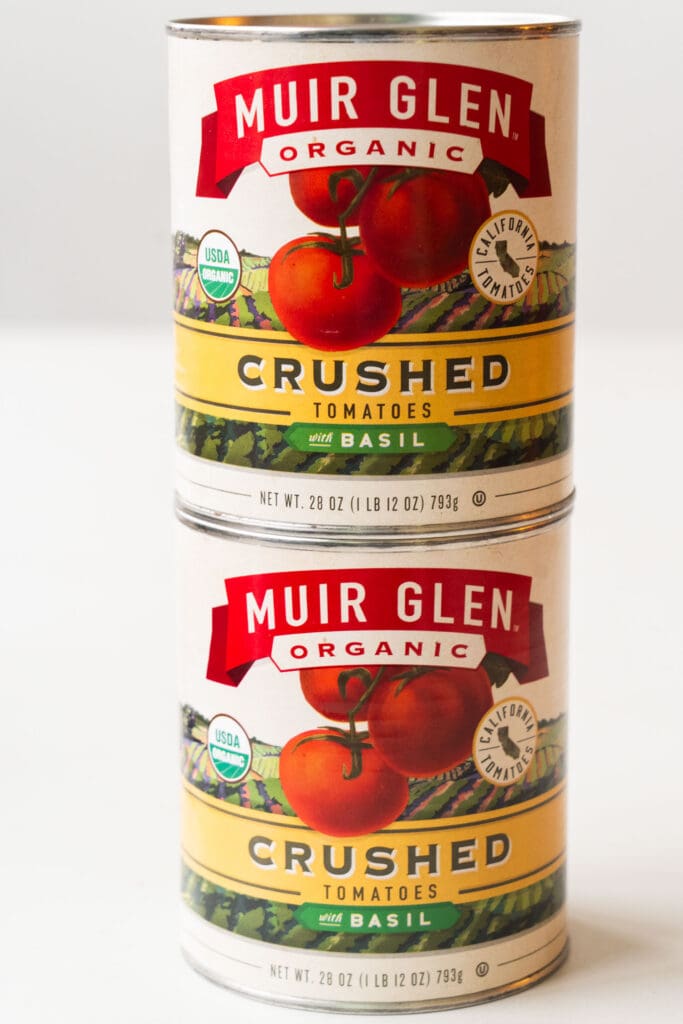 cans of crushed tomatoes on table.