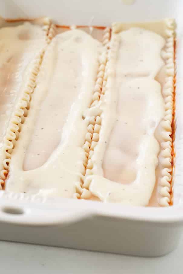 This white sauce lasagna recipe is one of our favorite comfort foods. Lasagna noodles are layered with spaghetti sauce, cheese, and a rich creamy alfredo inspired sauce. Serve it alongside a simple kale salad and garlic bread for a comfort meal that’s perfect for any time of the year!