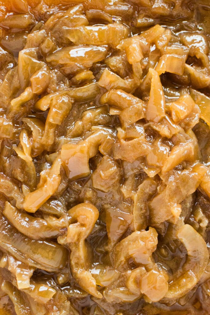 closeup of cooked caramelized onions in slow cooker.