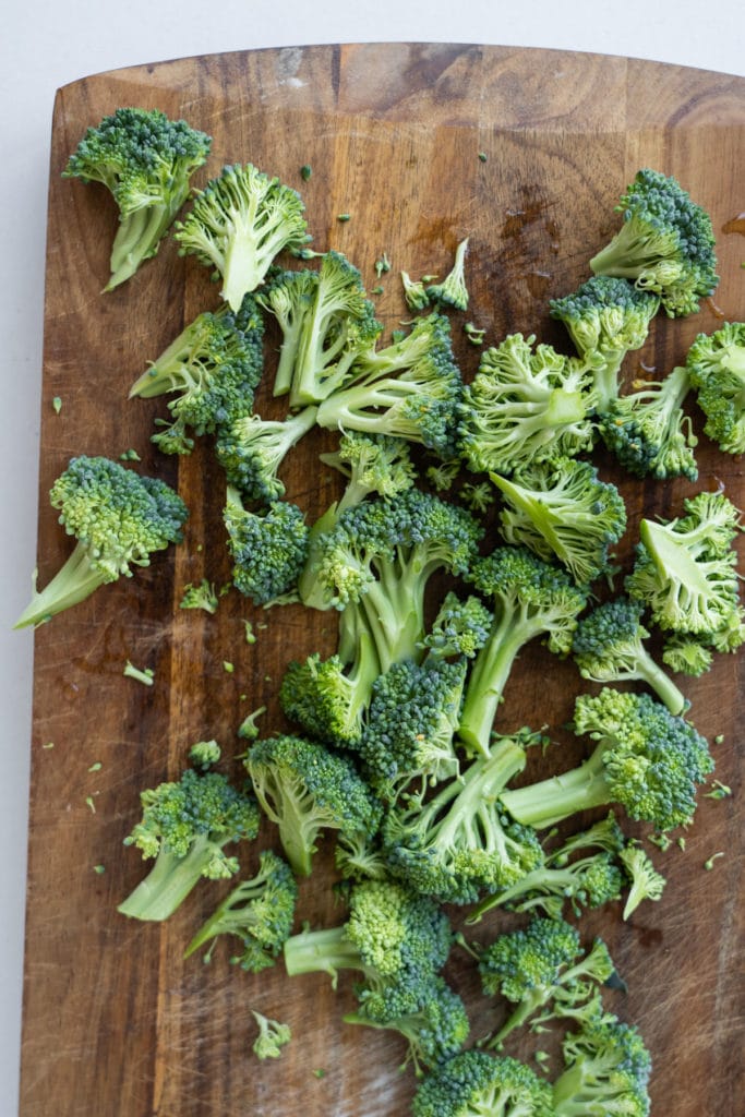 broccoli florets chopped up on cutting board