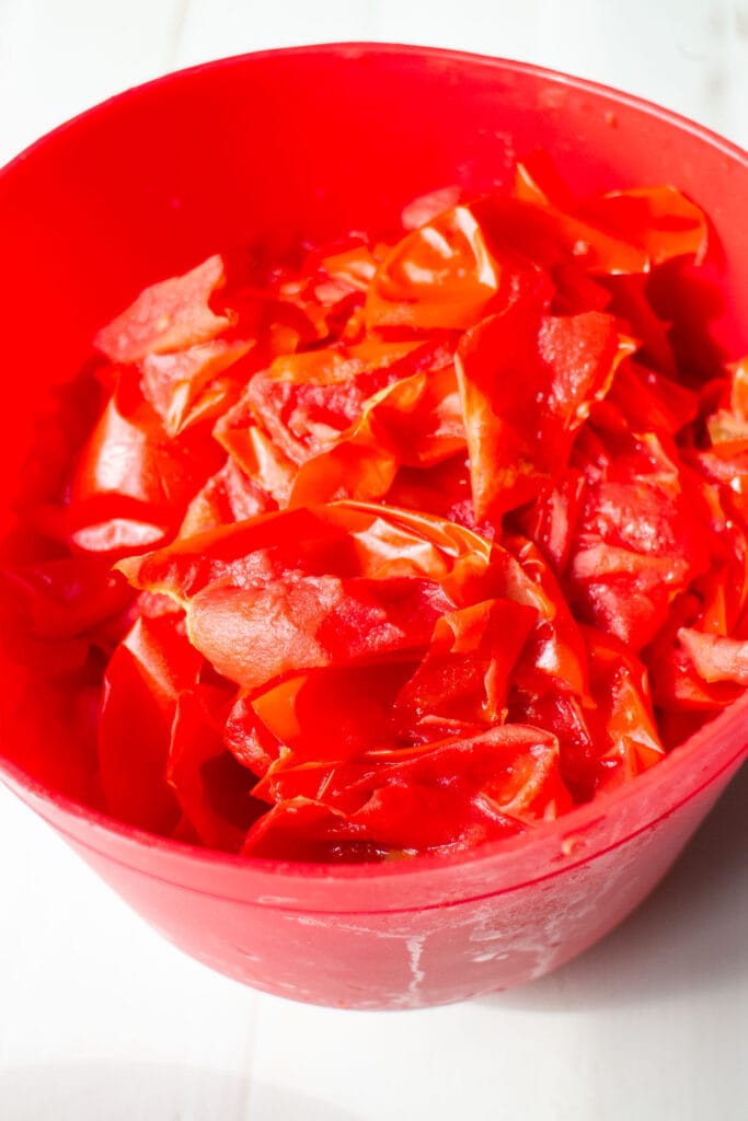 tomato skins in red bowl.