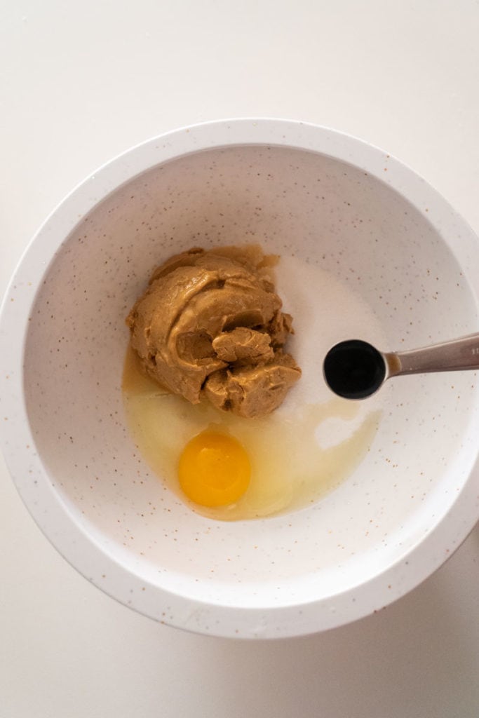 peanut butter, sugar, egg and vanilla in white bowl