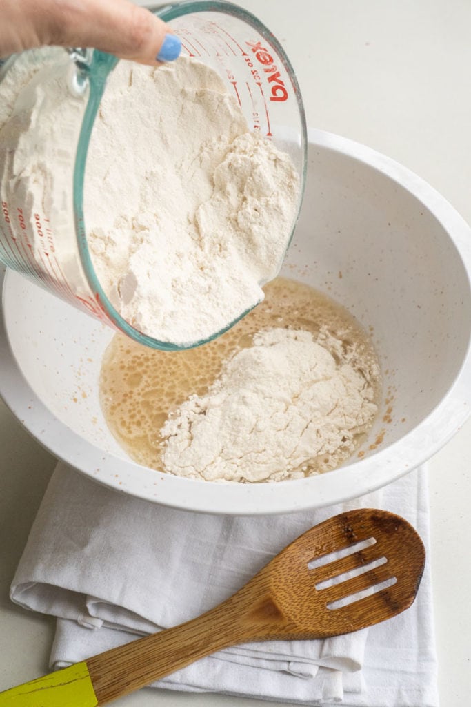 adding flour into bowl 