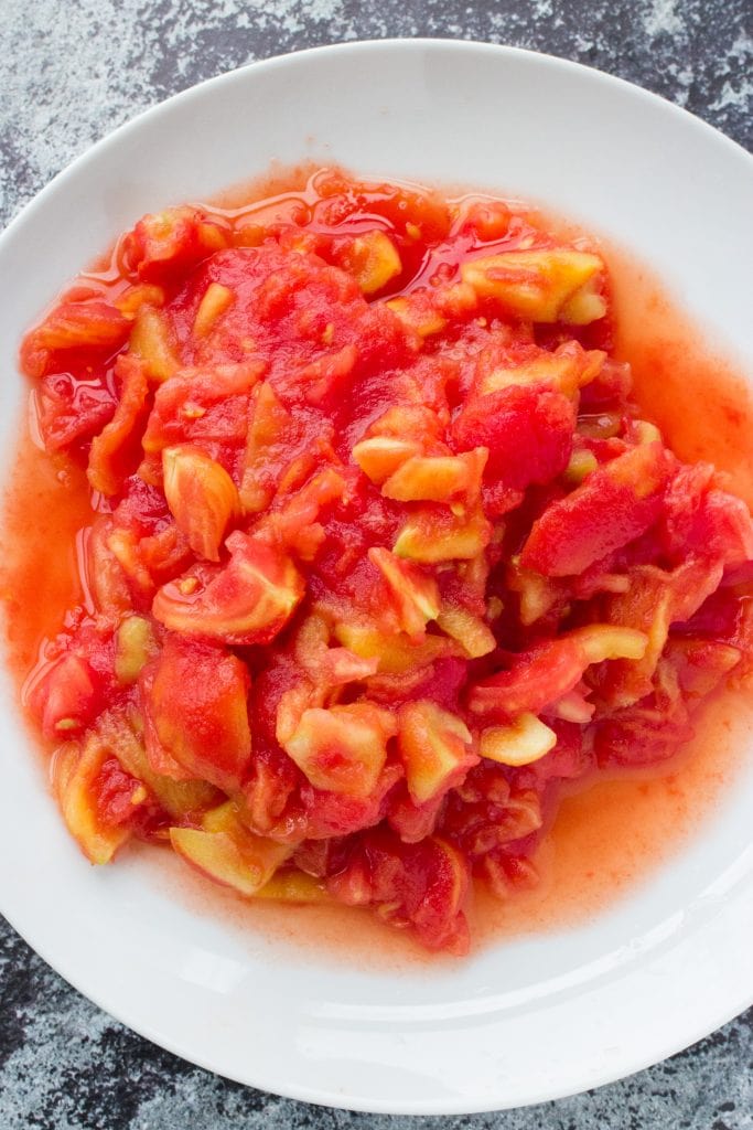 fresh tomatoes chopped up in white bowl. 