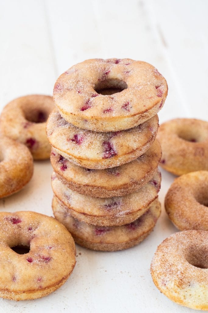 strawberry donuts in pile on top of each other on white table