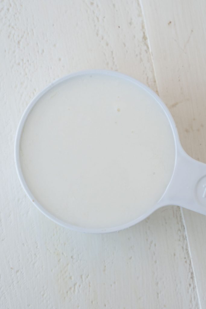 homemade buttermilk in white measuring cup