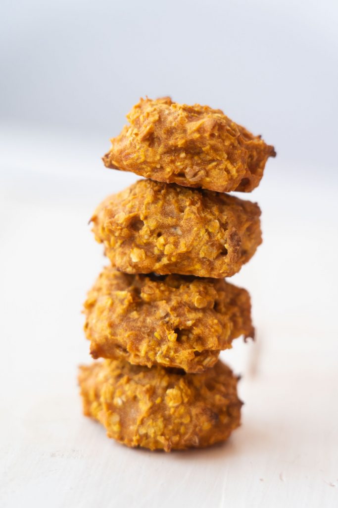 baked carrot baby cookies stacked up in pile on white table