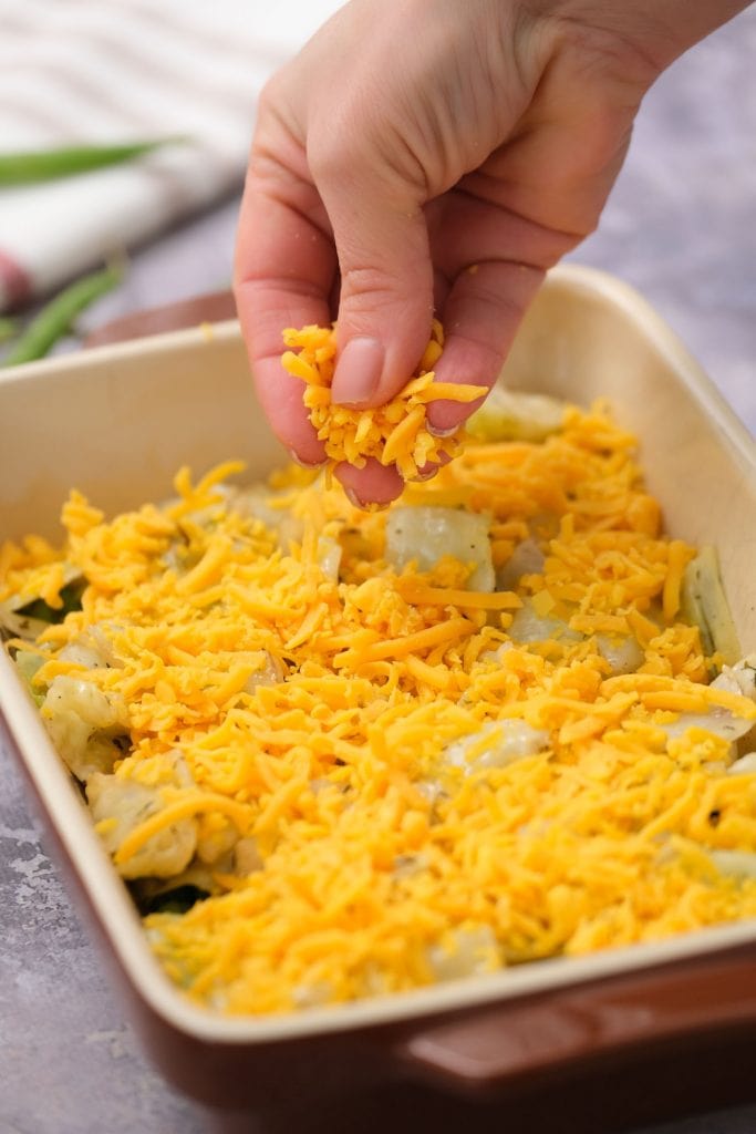 shredded cheese being added on top of cabbage