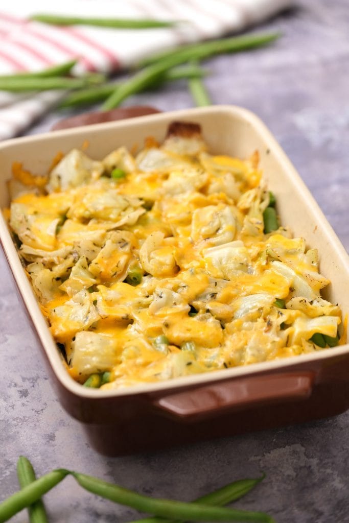 cheesy green beans and cabbage in baking dish on top of table